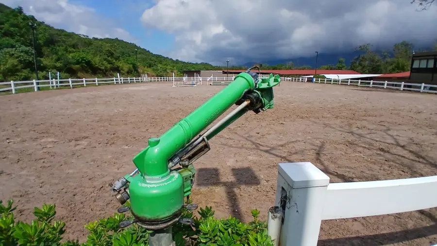 Cañón aspersor industrial regando una arena de gran formato